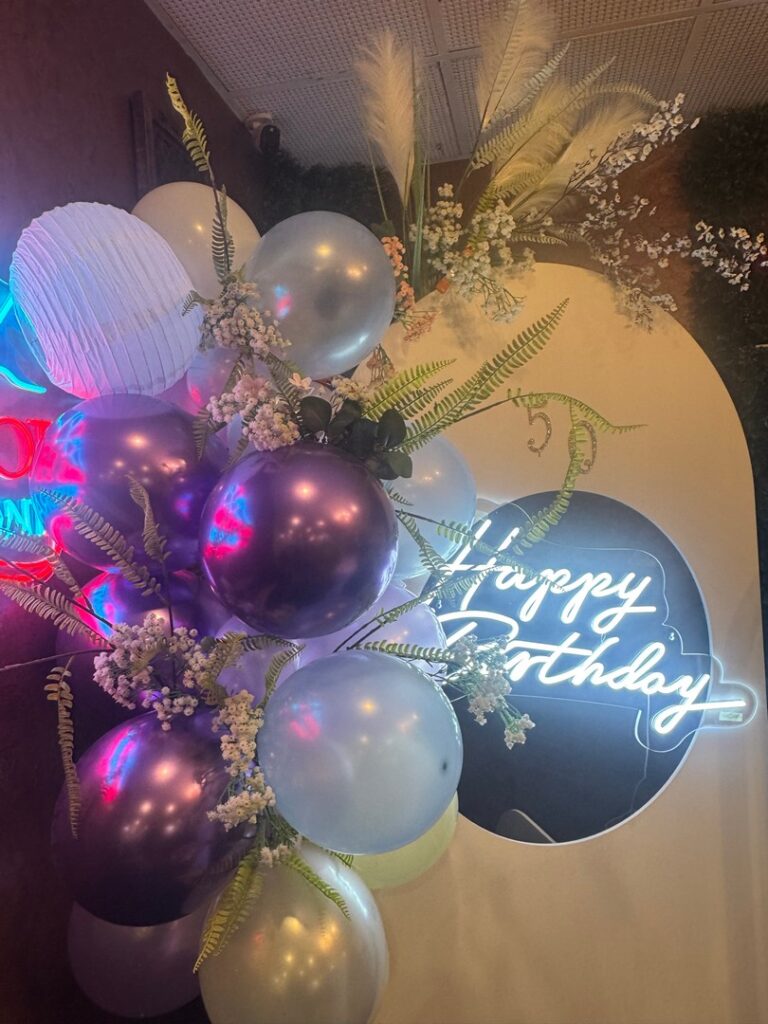 Elegant birthday event styling with balloons, florals, and neon sign by Saraya D Decor Adelaide