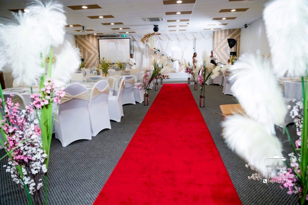 Full birthday event hall styling with floral aisle and stage by Saraya D Decor Adelaide