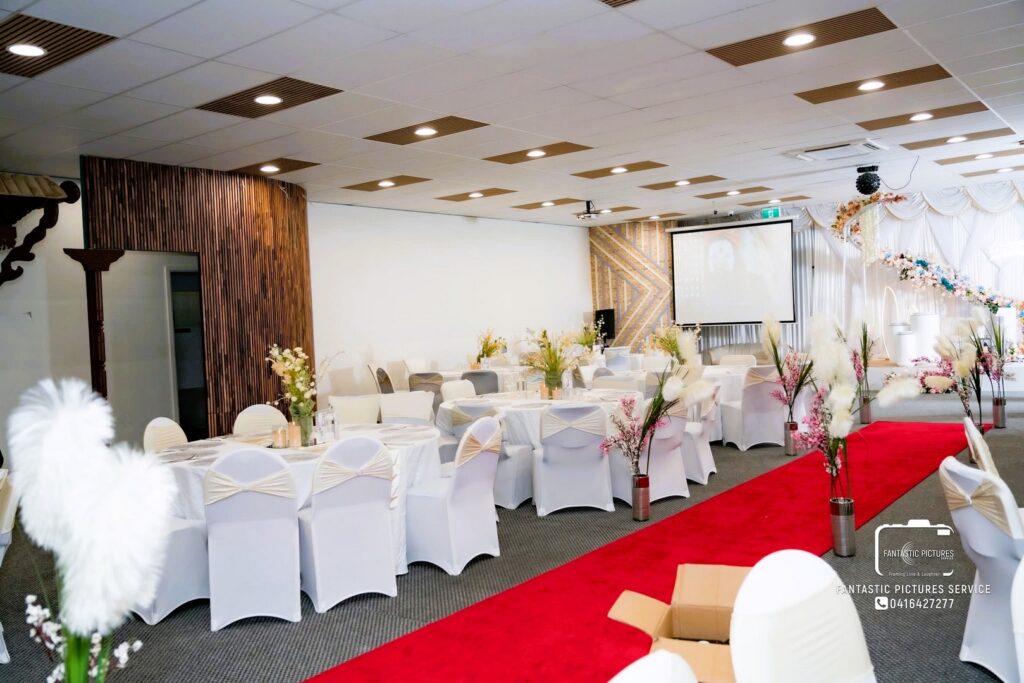 Elegant party hall decoration with floral aisle and draped stage by Saraya D Decor Adelaide
